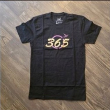 Overcomer Rainbow Tee | Black photographed on wood floor
